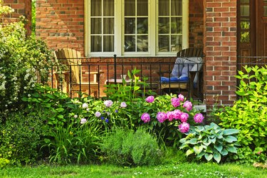 Garden growing below the front porch of a house