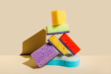 Colored sponges for washing dishes and cleaning on beige background. The concept of cleanliness in the house
