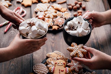 Friends eating festive sweets with hot chocolate