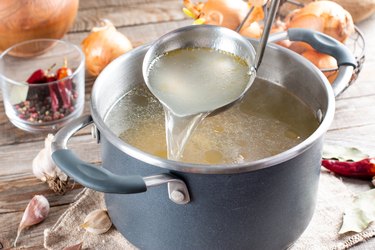 Saucepan with bouillon and a ladle