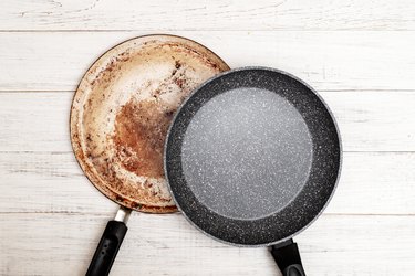 Comparison of pans. Old and new frying pan. New and old damaged non-stick coating.