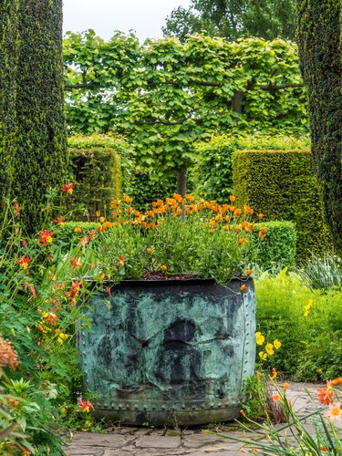 Sissinghurst Castle's garden with hedges and a large flower pot.