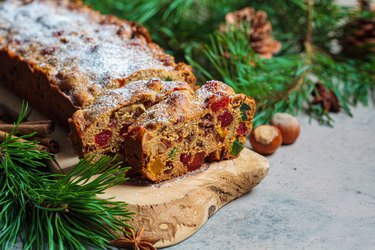 Traditional Christmas fruit cake on a wooden board amid festive decorations