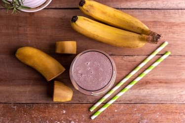 Banana smoothie in glass on wood table