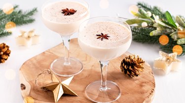 Eggnog on wooden tray, Christmas cocktail in coupe glass, top view