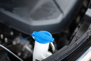 A blue plastic bottle cap of car windshield washer water.