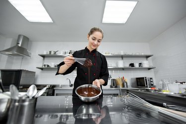 Pastry chef mixing chocolate ganache with a whisk