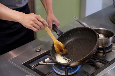 Asian Chief Making the Dish, Pan Fried Onion in Coating Cast Iron Pan