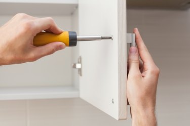 Installing handle on white cabinet