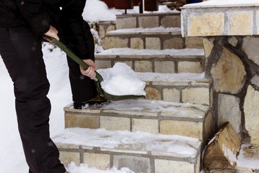 Man cleaning snow with shovel