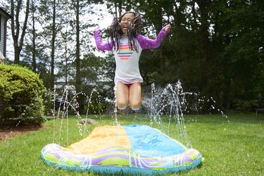 Asian Girl jumping on slip and slide