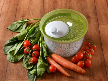 Centrifugal dryer for salad with vegetables around - closeup