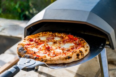 Making homemade pizza in portable high temperature pizza oven.