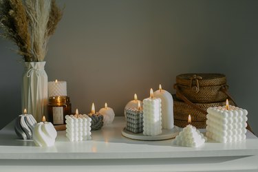 White dresser with dried flowers in vase,Rattan bags and variety candles Still life,Hygge concept