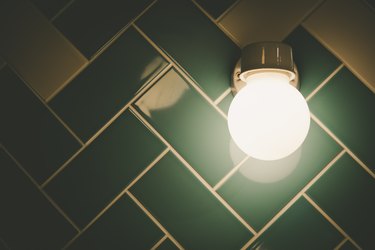 Round Light Fixture On Tiled Bathroom Wall With Copy Space