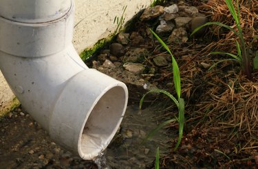 Close-up of a buildings down spout with splashing rain water