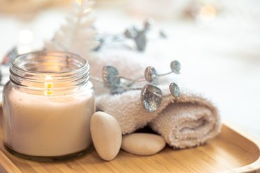 Christmas spa composition with a candle on blurred background, close-up.