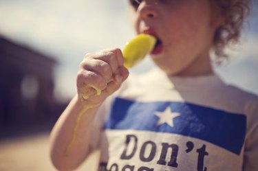 Child eating melting popsicle