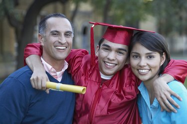 Portrait of a female graduate standing with a mid adult man and a young woman