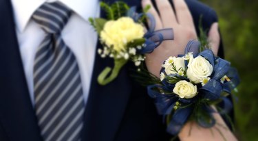 Hands of date Prom night flowers corsage formal wear hand on shoulder selective focus blur