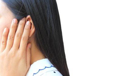 Tinnitus, young woman has pain in the ear