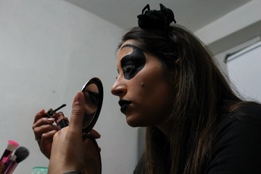 young girl putting on makeup for Halloween night