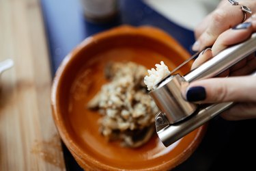 Woman hand pressing garlic masher