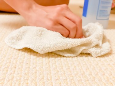 mixed-race teen girl tries to remove stain from carpet