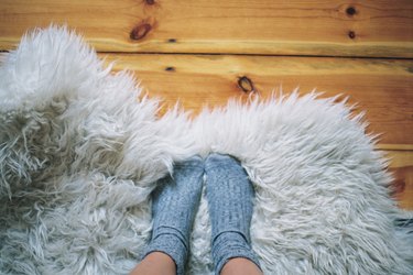 Womans feet wearing socks on a rug