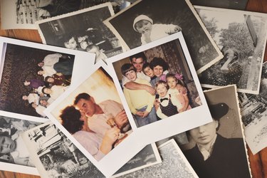 Pile of family photographs on table, overhead view