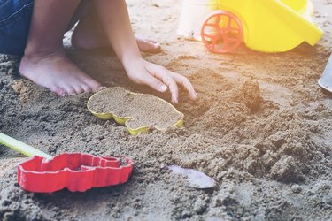 Girl playing with toys on sand