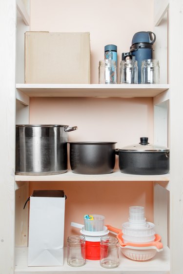 Shelving in the pantry with home cooking utensils and boxes close-up