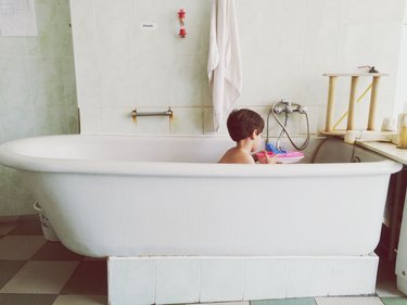 Boy Playing With Toy Boat In Bathtub