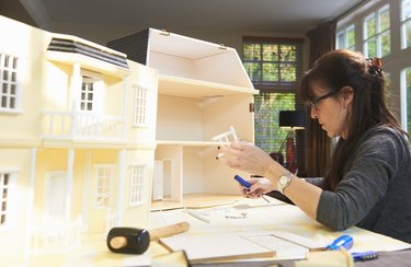Woman building a doll house