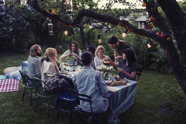 Multi-ethnic friends having food at dining table in yard