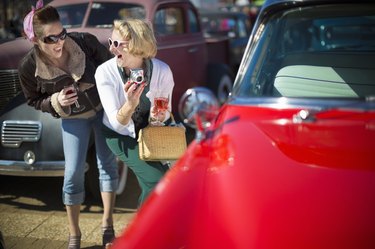 Woman taking picture of vintage car