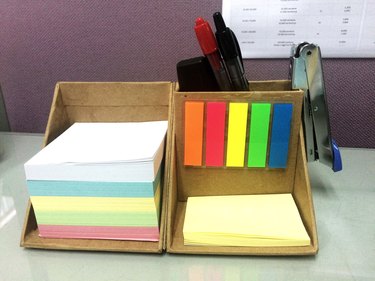 Close-Up Of Desk Organizer With Colorful Adhesive Notes At Office