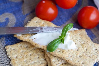 Crackers with stracchino cheese. Closeup.