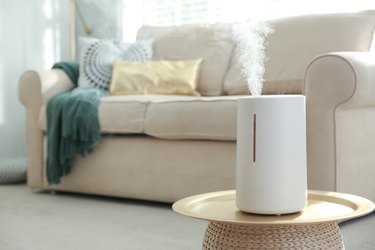 Modern air humidifier on table in living room.
