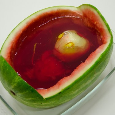 Carved apple alien floating in watermelon filled with red jello