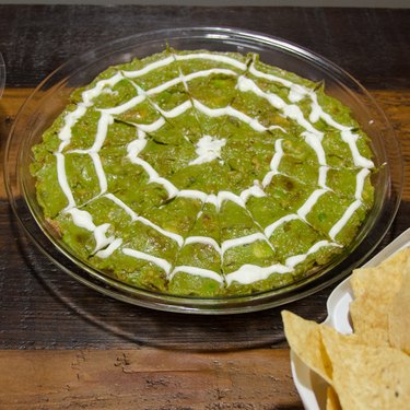 Guacomole topped with a sour cream spider web