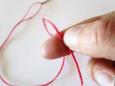 Threading a needle and tying a knot - yarn 