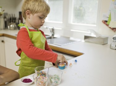Boy decorating cupcake