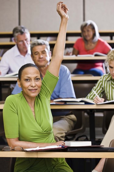 Student raising hand in lecture hall