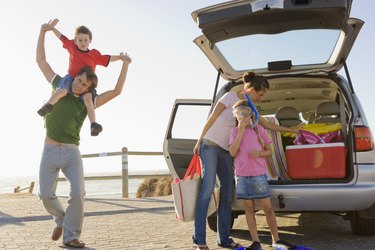 Family playing by van