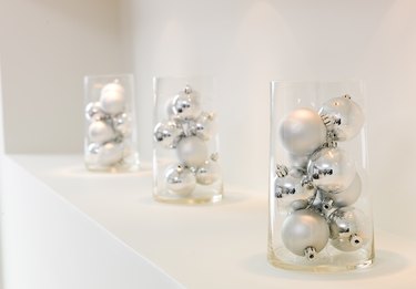 Glass containers of silver ornaments on mantle