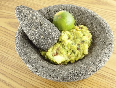 Molcajete Mortar Pestle Bowl Filled With Guacamole And A Lim