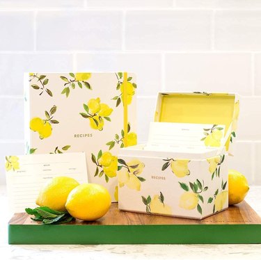 Recipe book and holder in a lemon pattern against a subway tile background.