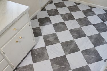 Faux marble peel and stick floor tiles laid in a diamond harlequin pattern