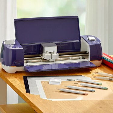 A purple Cricut machine with supplies and tools